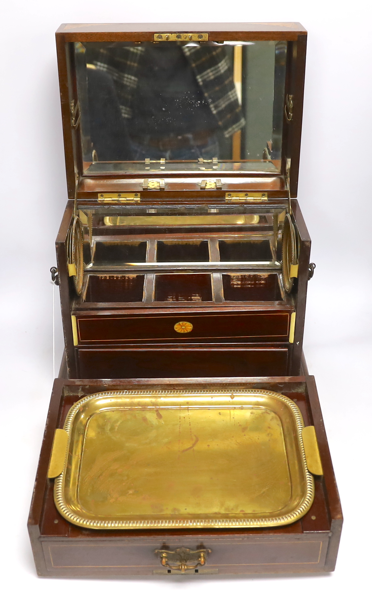 An Edwardian Sheraton revival inlaid mahogany portable drinks cabinet with tantalus and other accessories including serving trays, a brass cribbage board, with secret drawer, etc, 37cm high
